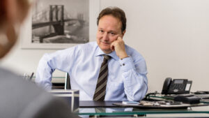 Businessporträt vom Corporate Fotografen Jan Haeselich aus Hamburg - Anwalt im Beratungsgespräch am Schreibtisch